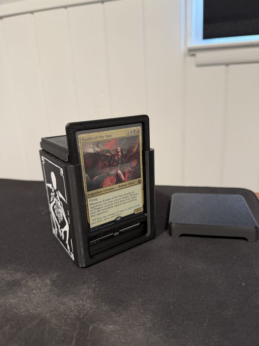 The deck box open with the lid off and a Magic card standing in the front display slot