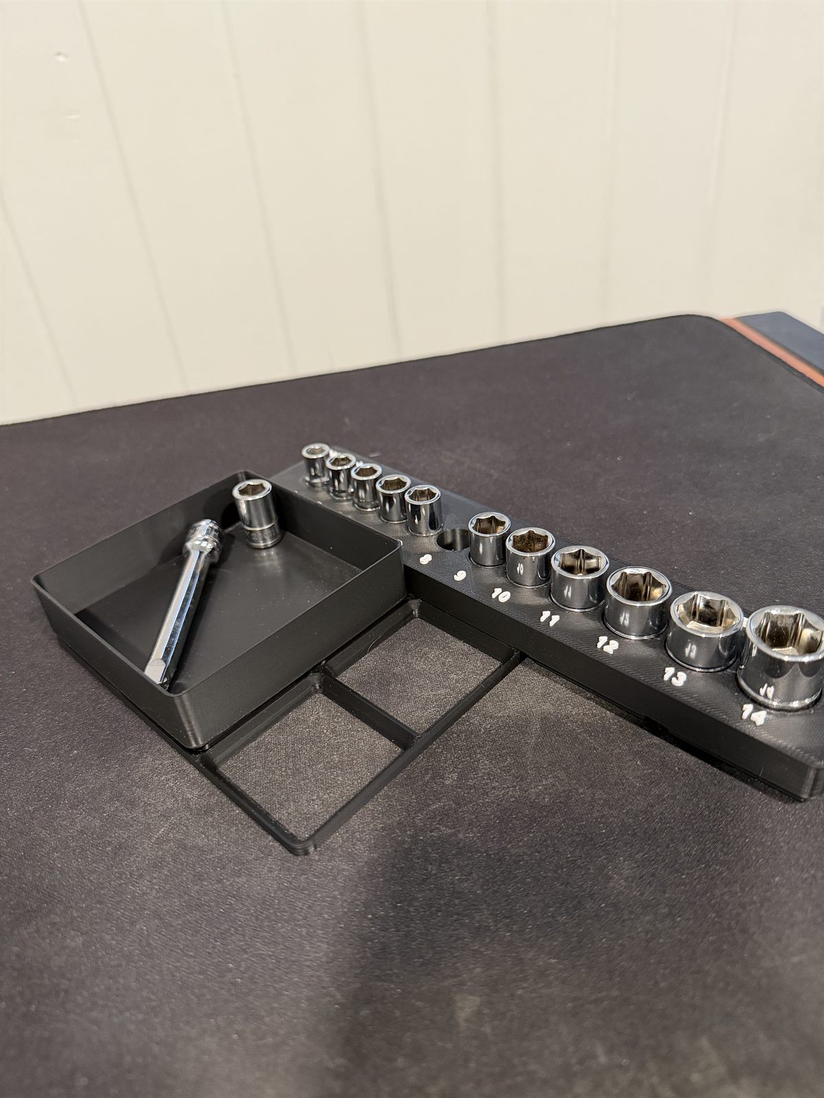 A 3D-printed socket rail with sockets labeled by size beside a small magnetic parts tray