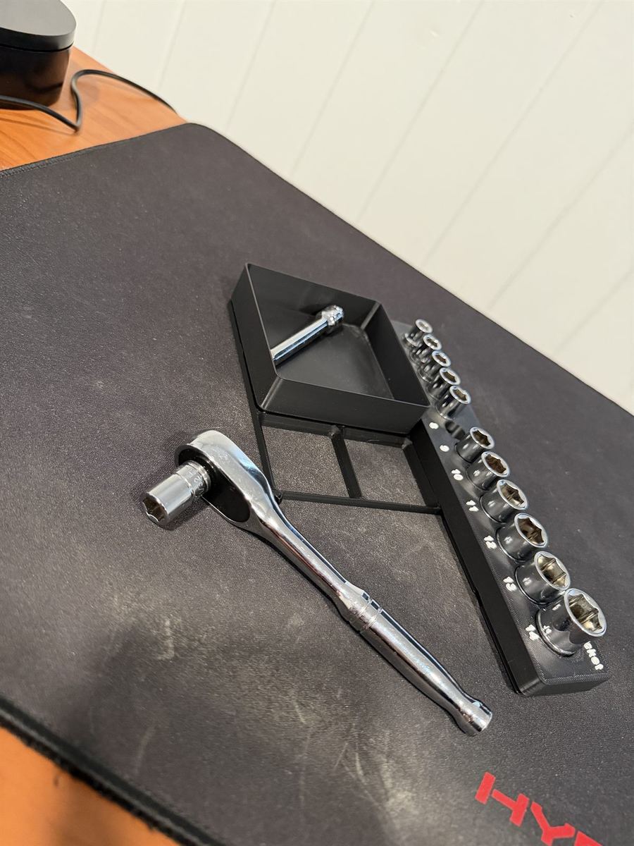 Gridfinity trays holding a ratchet and a row of sockets on a desk mat