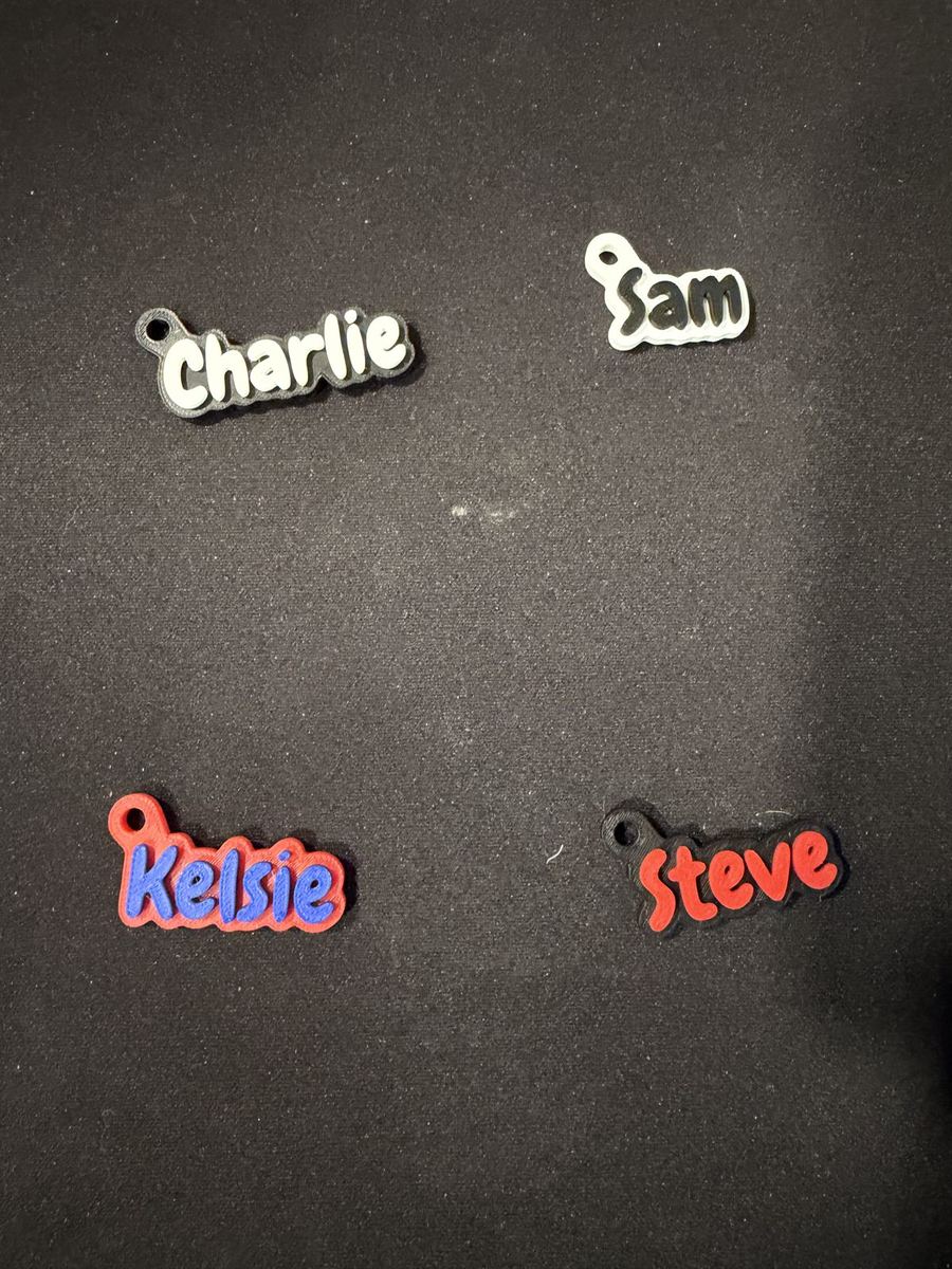 Four 3D-printed name keychains reading Charlie, Sam, Kelsie, and Steve in different colors
